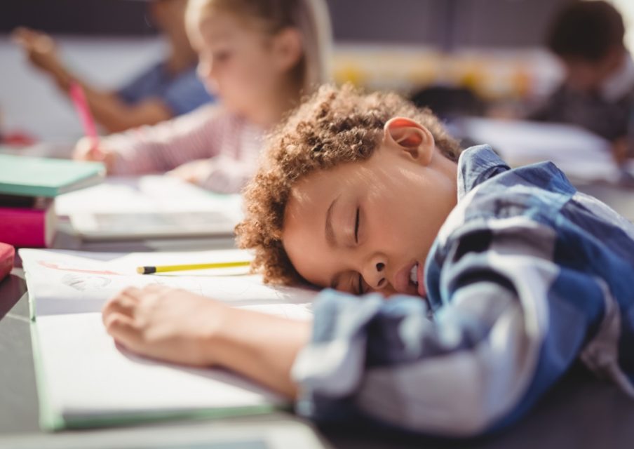 enfant endormi sur sa table d'école
